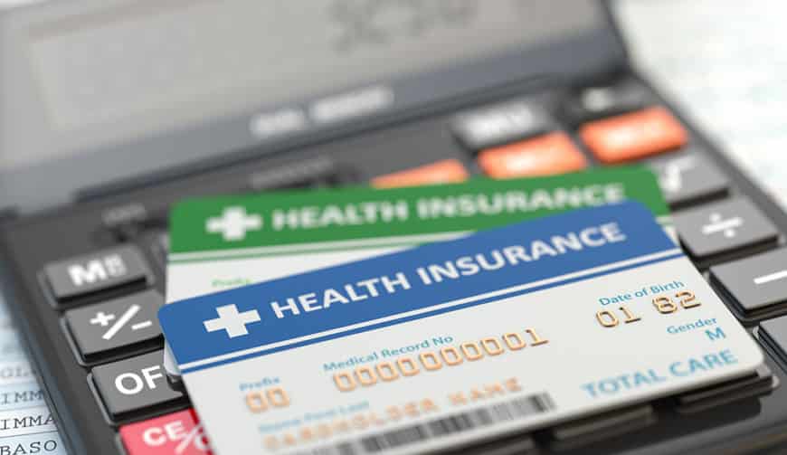 Medical insurance cards on the calculator. Health care costs concept. 3d illustration