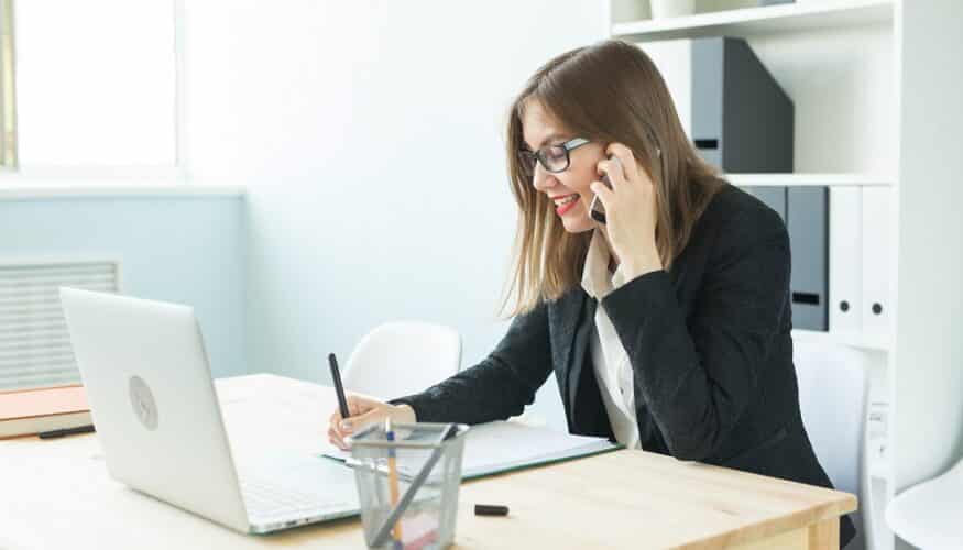 Business, realtor and people concept - Attractive woman in office talking on phone and make notes.