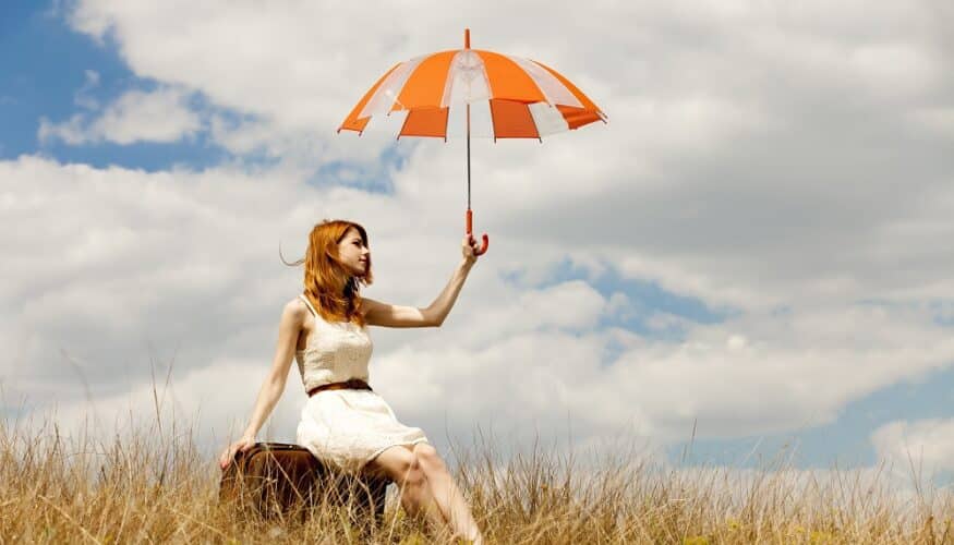 redhead with umbrella in a field