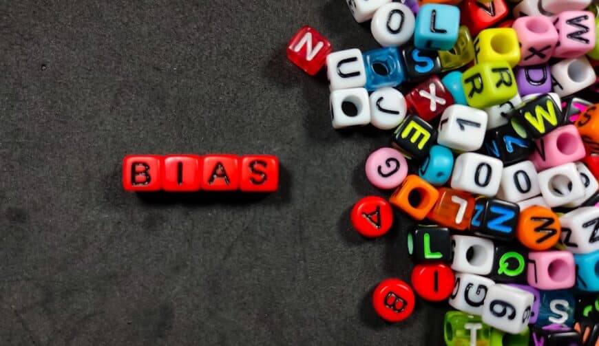 Selective focus.Colorful dice with color letter in word BIAS on black background.